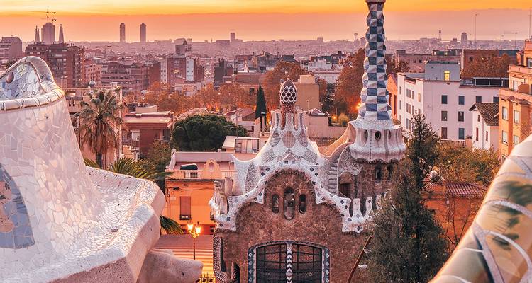 Architecture en mosaïque colorée avec vue sur la ville au coucher du soleil.