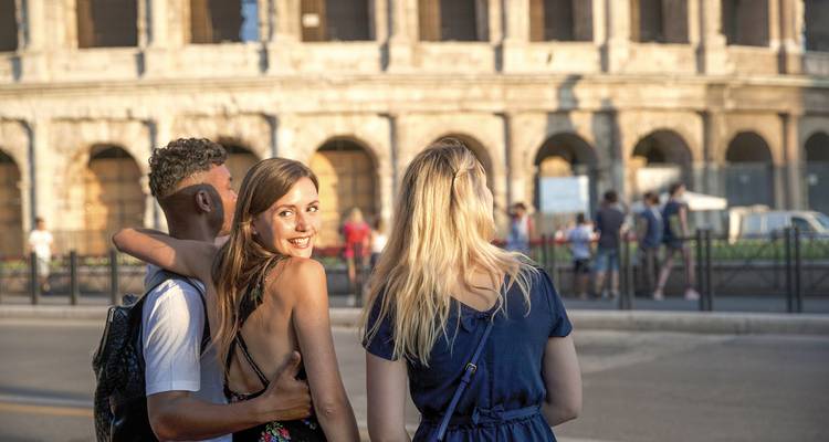 People posing in front of the Colosseum.