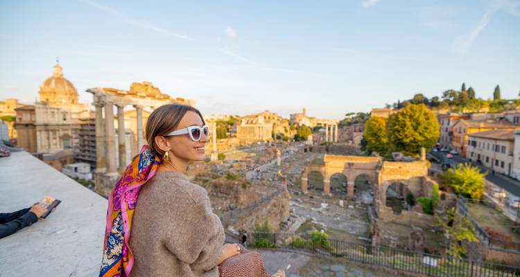 Woman sitting overlooking the Roman Forum in Rome, Italy.
