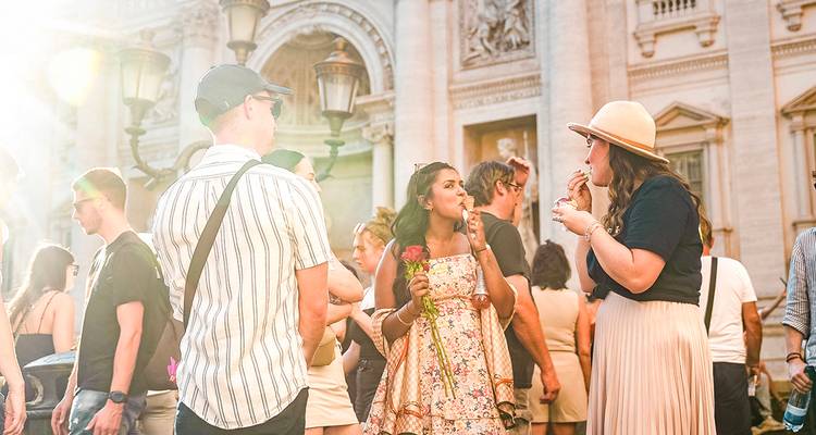 Une foule se rassemble devant la façade de marbre ornée de la fontaine de Trevi baignée de soleil chaleureux