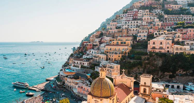 Pueblo colorido en la ladera con barcos en primer plano.