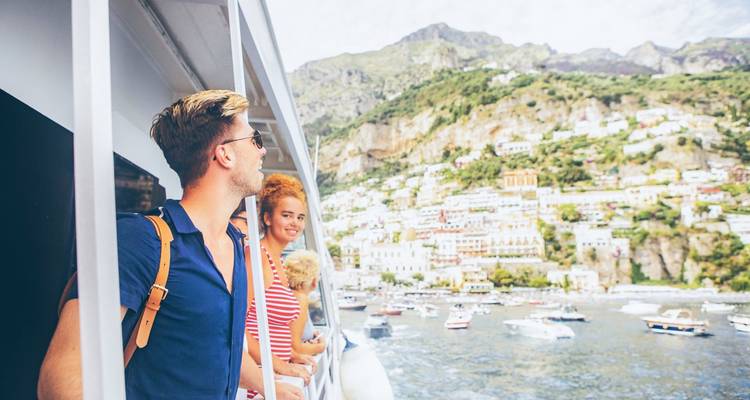 People on a boat with a scenic coastal backdrop.