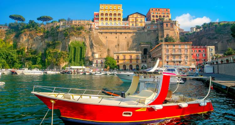 Sorrento kustlijn met kleurrijke huizen en boten aangemeerd aan de kust.