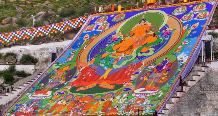 Grote kleurrijke muurschildering van een godheid op een heuvel.