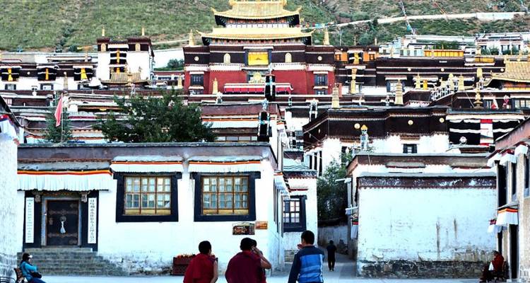 Monniken die lopen richting Tashilhunpo Klooster met traditionele architectuur.