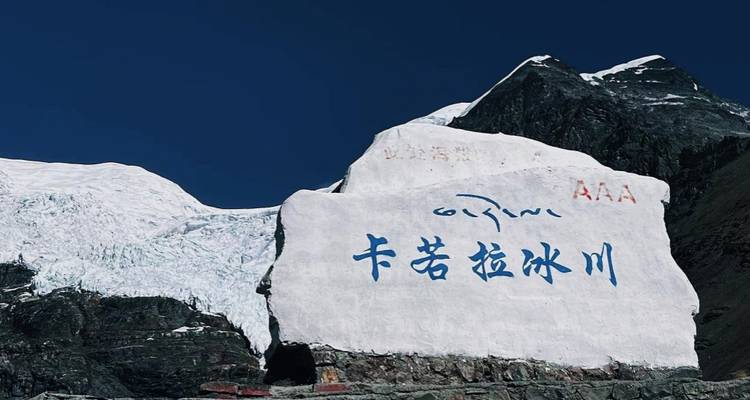 Grote rots met inscripties naast een gletsjer.