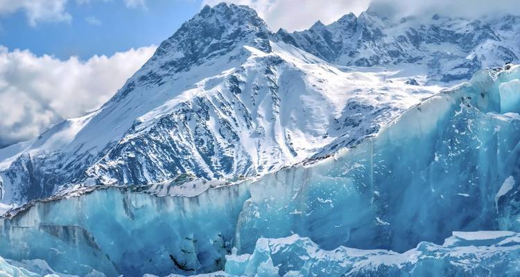 Snow-covered mountains and icebergs in a cold climate landscape.