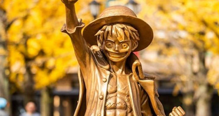 Statue of an anime character in an autumn setting.