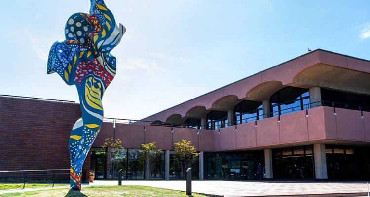Colorful modern sculpture outside a contemporary building.
