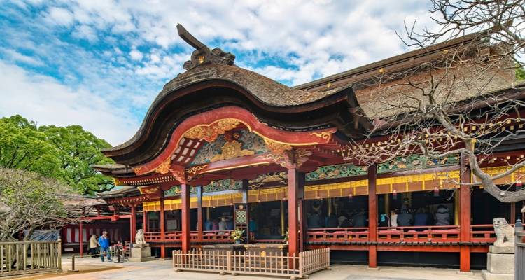 Traditional Japanese shrine with people visiting.