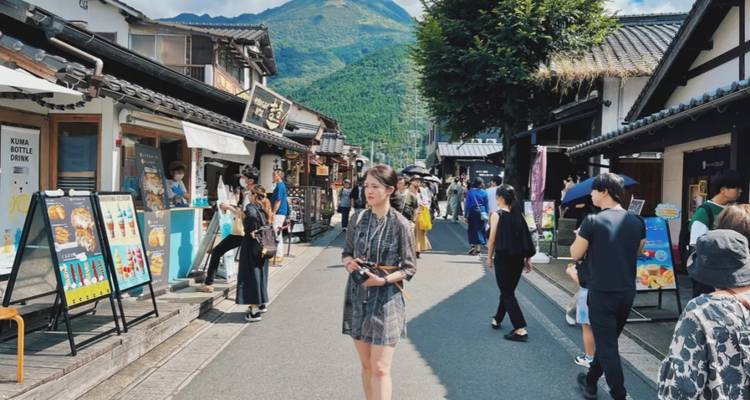 Busy street market with tourists and local shops.
