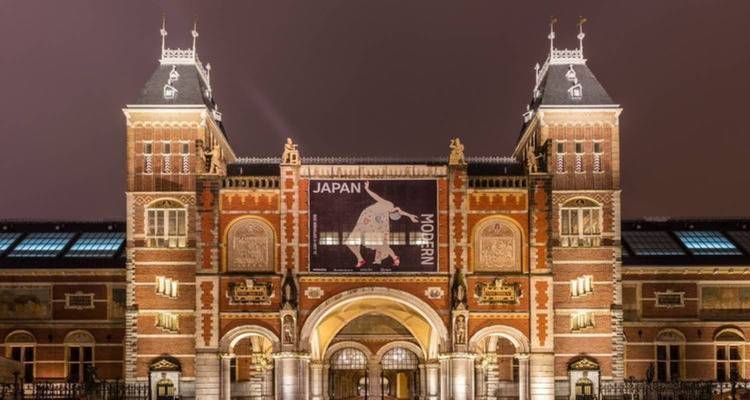 Exterior of a historic museum building with banners at night.