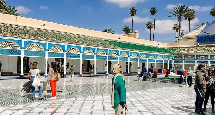 Des gens qui marchent dans une cour ouverte avec des sols carrelés.