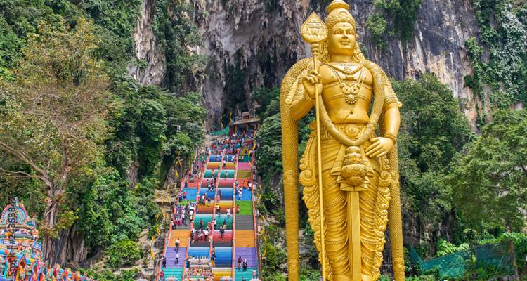 The Batu Caves in Malaysia with colorful steps and a large statue.
