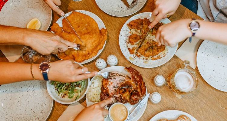 Groupe de mains partageant un repas traditionnel à une table à manger.