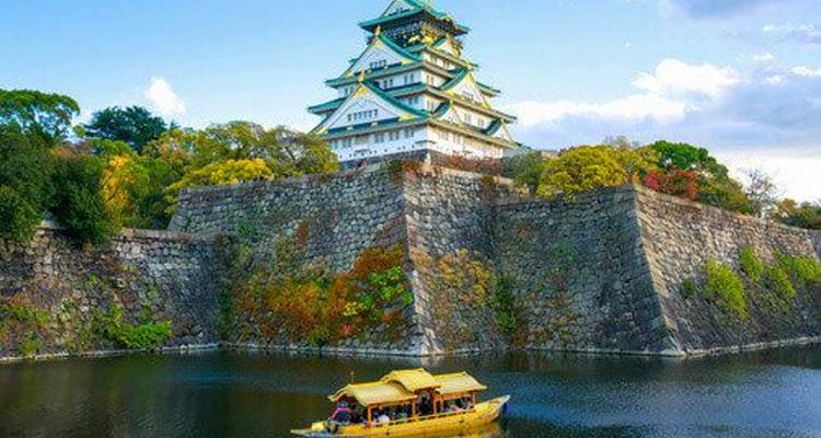 Castillo de Osaka con un barco en el foso circundante en otoño.