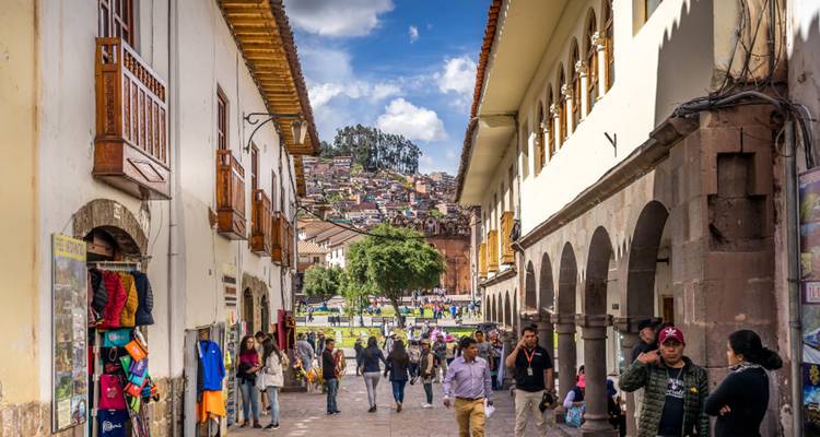 Drukke voetgangersstraat in Cusco omzoomd met koloniale arcades en winkels met locals en toeristen