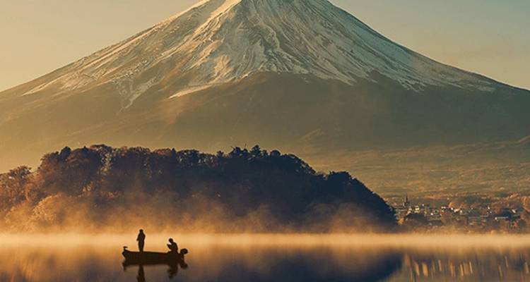 Bateau de pêche sur un lac avec le mont Fuji en arrière-plan.