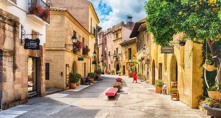 Charmante Fußgängerstraße mit Steinbögen, Blumentöpfen und Boutiquen in Barcelonas Poble Espanyol
