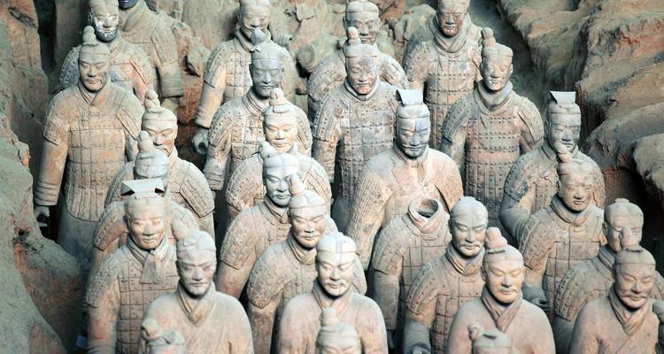 Terracotta strijder standbeelden staan in ordelijke rijen binnen de opgravingskuil in Xi'an