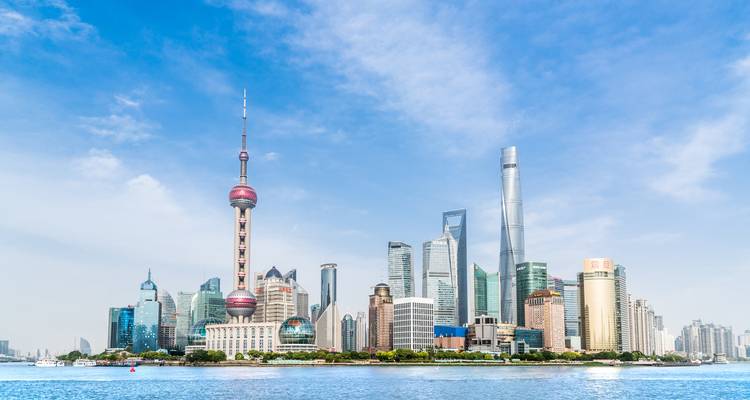 Ikonische moderne Skyline von Shanghai mit dem Oriental Pearl Tower und gläsernen Wolkenkratzern, die sich im Huangpu-Fluss spiegeln