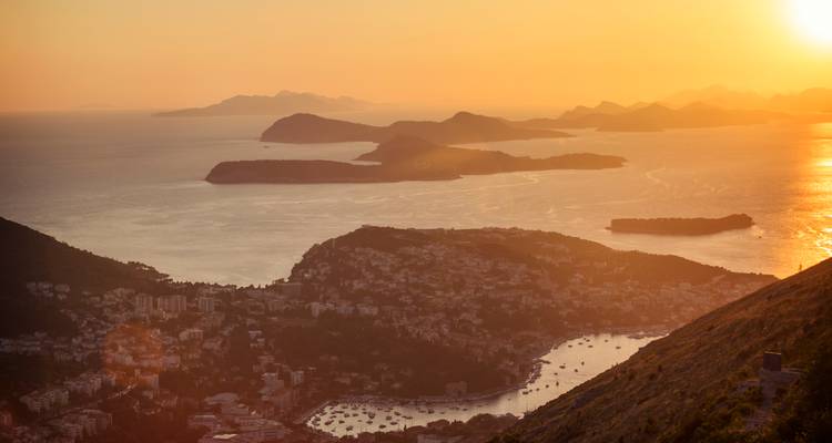 Coucher de soleil doré sur les îles adriatiques dispersées et le littoral en dessous, vu depuis un belvédère en hauteur