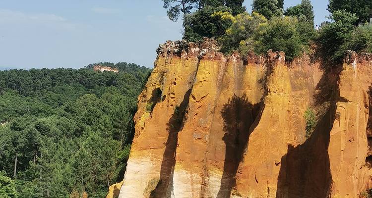 Formations rocheuses orange et arbres verts.