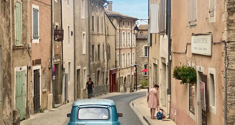 Vue de rue avec voiture vintage et personnes.