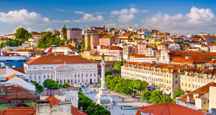 Vista panorámica del paisaje urbano de Lisboa con edificios históricos y un monumento central.