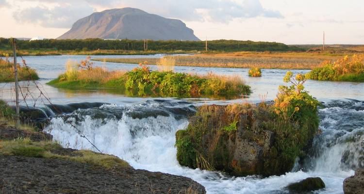 Une petite cascade et un ruisseau qui coulent à travers un paysage rocheux.