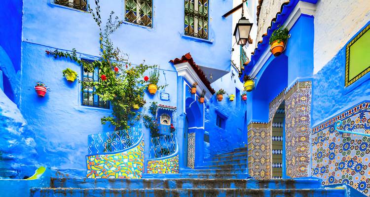 Une rue animée avec des bâtiments peints en bleu et des décorations colorées.