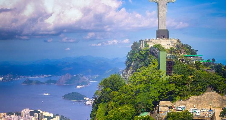 La statue du Christ Rédempteur surplombant un paysage urbain et l'océan.