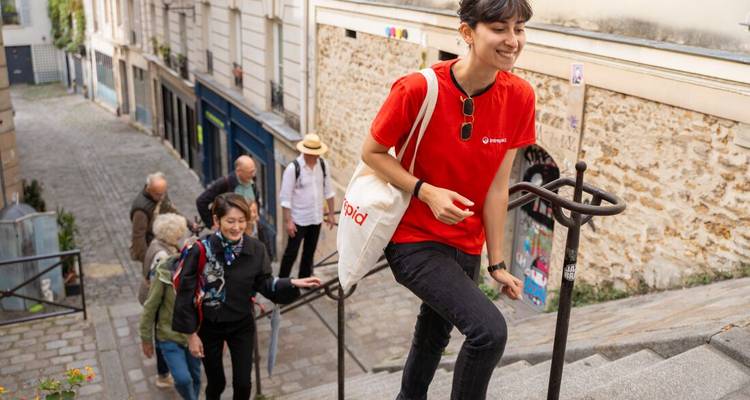 Guide touristique menant un groupe dans les marches d'une charmante ruelle