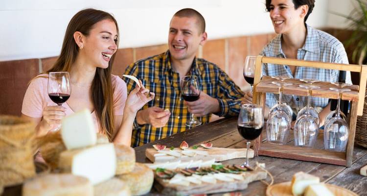 Des amis savourant du vin et du fromage à table