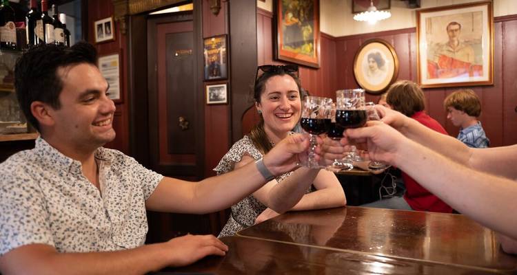 Groep vrienden die proosten met wijn in een gezellige bar.