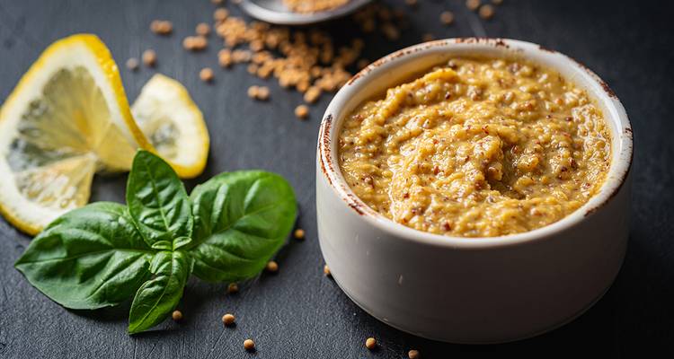 Gros plan de moutarde avec des herbes fraîches et des tranches de citron