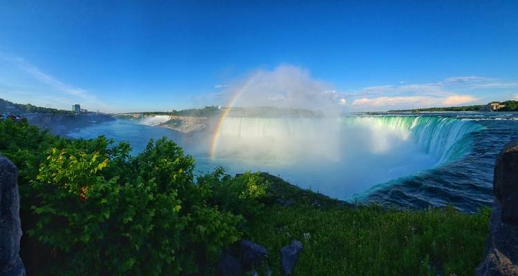 Panoramic view of Niagara Falls with a rainbow.