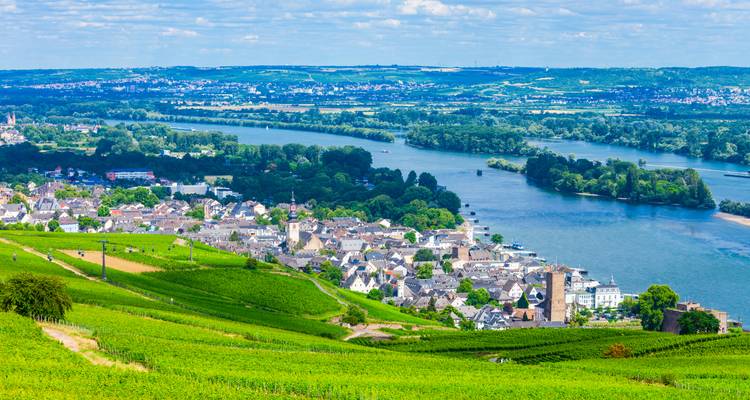 Vue aérienne d'une ville avec une rivière et un paysage vallonné.