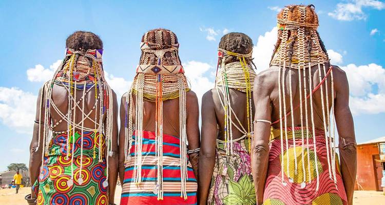 Four women with traditional braided hair facing away.