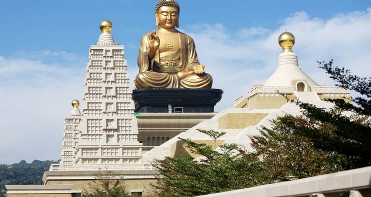 Large golden Buddha statue on a temple site.