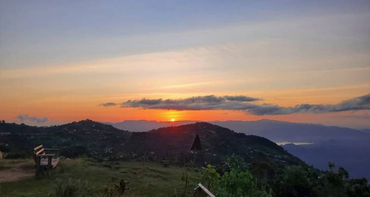 Zonsondergang over heuvelachtig landschap.