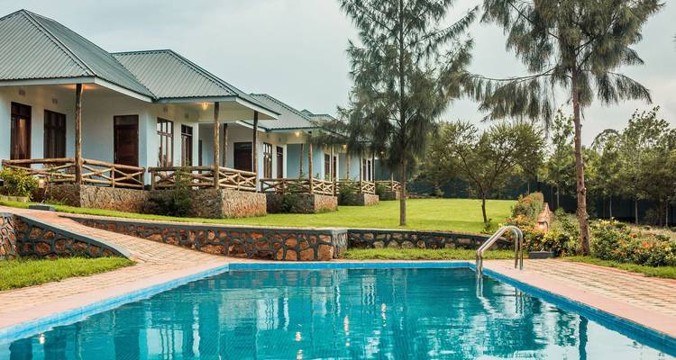 Un complexe hôtelier avec une piscine et des bungalows sur une zone herbeuse.