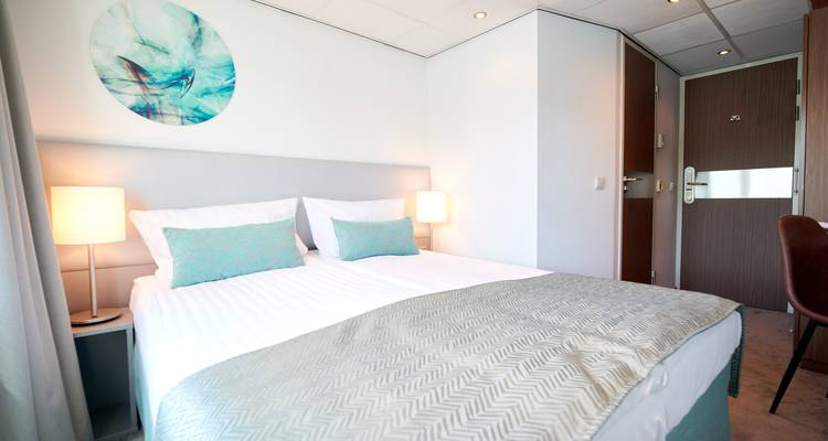 Vue intérieure de chambre d'hôtel avec lit et décoration.