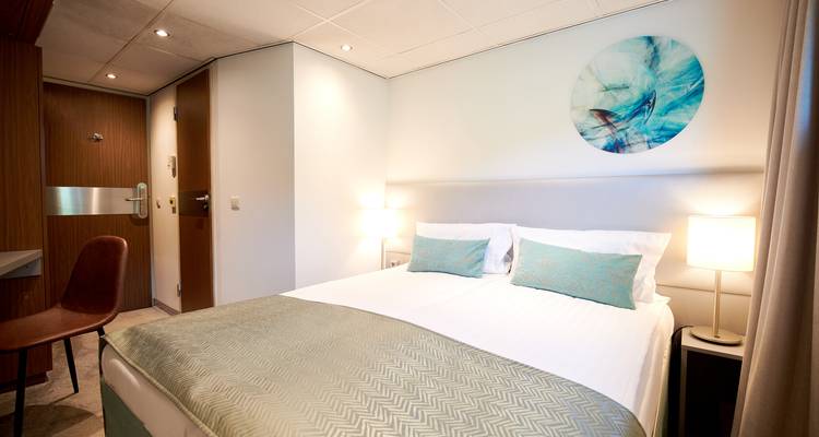 Chambre d'hôtel lumineuse avec intérieurs et décoration modernes.