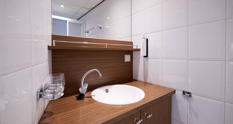 Petite salle de bain avec un lavabo et un miroir.