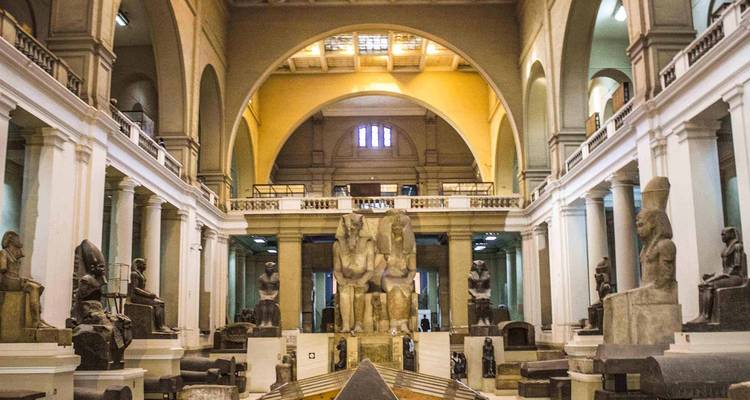 Interior of a grand museum with statues and artifacts displayed inside.