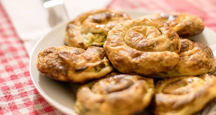 A plate of traditional pastries with a patterned tablecloth.