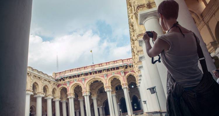 Person taking photos at a historical fort with ornate architecture.