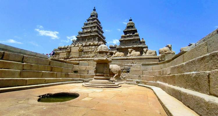 Ancient stone temple with carvings and blue sky.