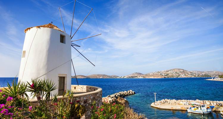 Moulin blanc sur une colline surplombant la mer.